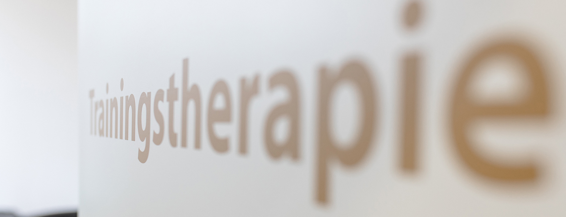 Aufschrift Trainingstherapie auf Tür zum Behandlungszimmer